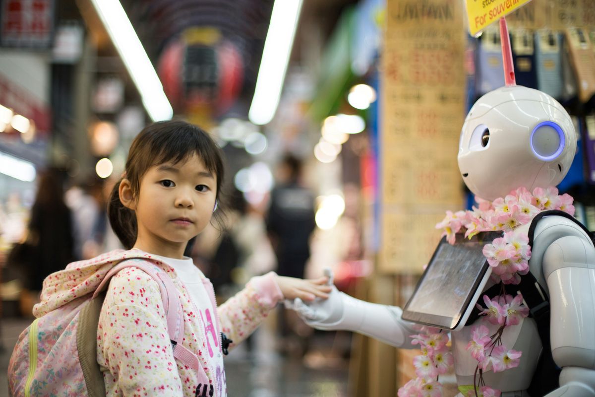A young girl holding hands with a friendly humanoid robot in a busy shopping street