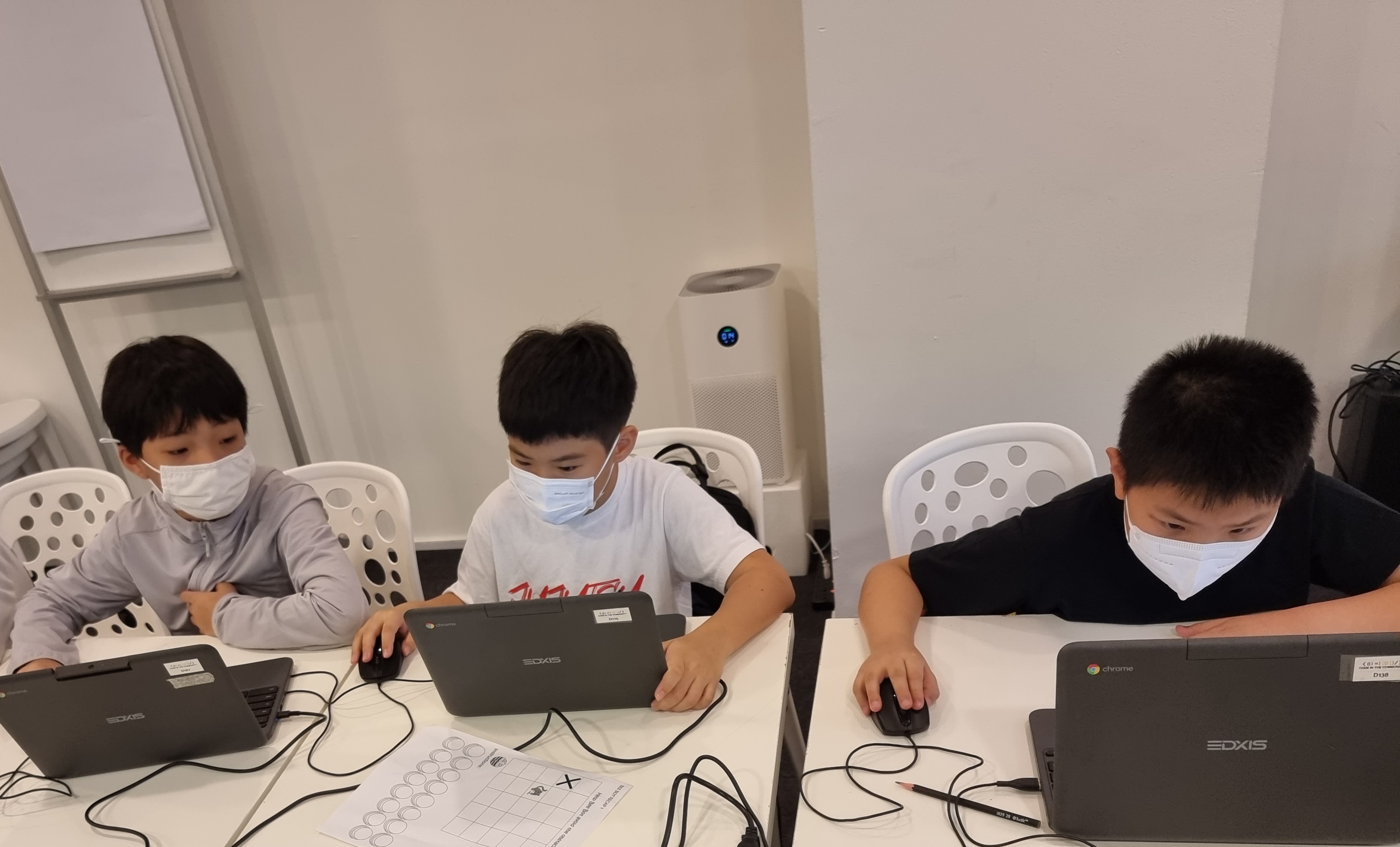 Kids working on laptops during a coding class at DotCode Campus