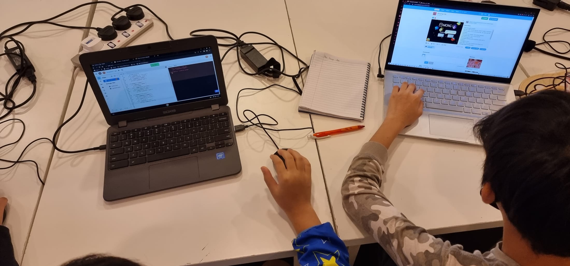Two students working side by side at their screens during a DotCode Campus class